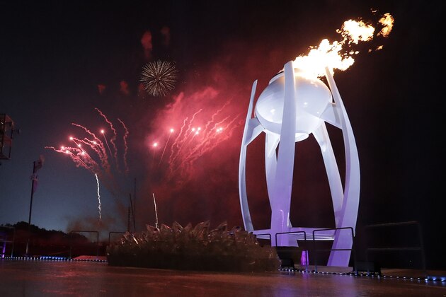 Fireworks explode behind the Olympic flame during the opening ceremony of the 2018 Winter Olympics in Pyeongchang, South Korea, Friday, Feb. 9, 2018. (AP Photo/David J. Phillip,Pool)