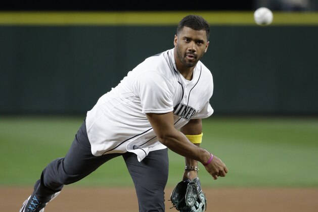 Seattle Seahawks quarterback Russell Wilson throws out the ceremonial first pitch before a baseball game between the Seattle Mariners and Los Angeles Angels Friday, Sept. 2, 2016, in Seattle. (AP Photo/Elaine Thompson)