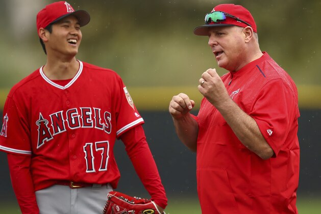 Los Angeles Angels' Shohei Ohtani, left, smiles at coach Mike Scioscia during a spring training baseball practice on Wednesday, Feb. 14, 2018, in Tempe, Ariz. (AP Photo/Ben Margot)