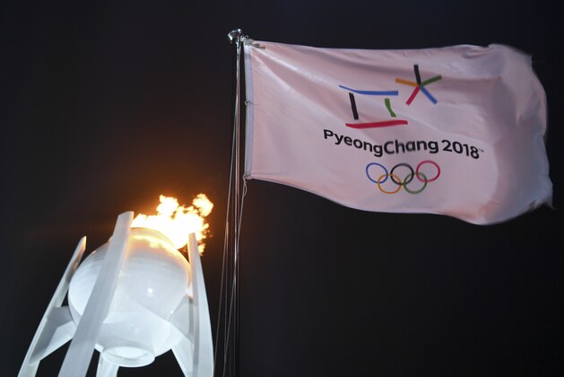 A flag flies in front of the Olympic flame during the opening ceremony of the 2018 Winter Olympics in Pyeongchang, South Korea, Friday, Feb. 9, 2018. (Franck Fife/Pool Photo via AP)