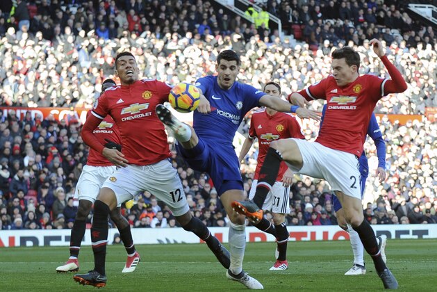 Chelsea's Alvaro Morata, center, challenges for the ball with Manchester United's Chris Smalling, left, and Victor Lindelof during the English Premier League soccer match between Manchester United and Chelsea at the Old Trafford stadium in Manchester, England, Sunday, Feb. 25, 2018. (AP Photo/Rui Vieira)