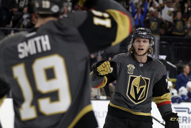 Vegas Golden Knights right wing Reilly Smith (19) congratulates center William Karlsson after Karlsson scored during the first period of the team's NHL hockey game against the Vancouver Canucks on Friday, Feb. 23, 2018, in Las Vegas. (AP Photo/Isaac Brekken)