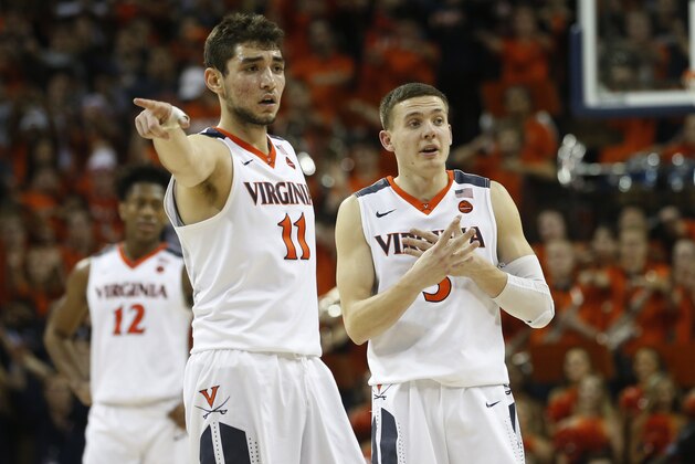 Virginia guard Ty Jerome (11) and Virginia guard Kyle Guy (5) look sot he bench during the second half of an NCAA college basketball game in Charlottesville, Va., Saturday, Feb. 10, 2018. Virginia Tech won the game 61-60 in overtime. (AP Photo/Steve Helber)