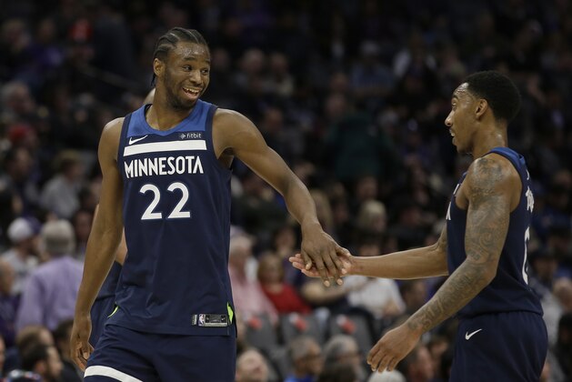 Minnesota Timberwolves forward Andrew Wiggins, left, slaps hands with teammate Jeff Teague as they leave the court during a timeout during the second half of an NBA basketball game against the Sacramento Kings, Monday, Feb. 26, 2018, in Sacramento, Calif. The Timberwolves won 118-100. (AP Photo/Rich Pedroncelli)