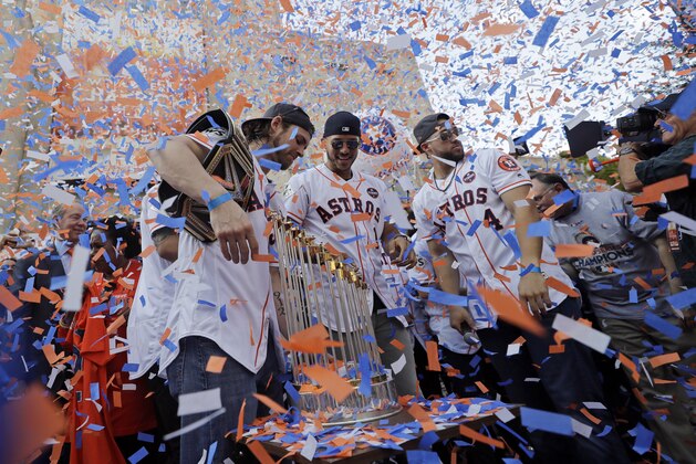 Houston Astros players, from left, Josh Reddick, Carlos Correa (1) and George Springer (4) celebrate during a rally honoring the World Series baseball champions Friday, Nov. 3, 2017, in Houston. (AP Photo/David J. Phillip)