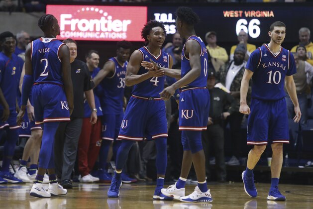Kansas guard Devonte' Graham (4) and guard Marcus Garrett (0) celebrate during the second half of an NCAA college basketball game against West Virginia, Monday, Jan. 15, 2018, in Morgantown, W.Va. Kansas won, 71-66. (AP Photo/Raymond Thompson)