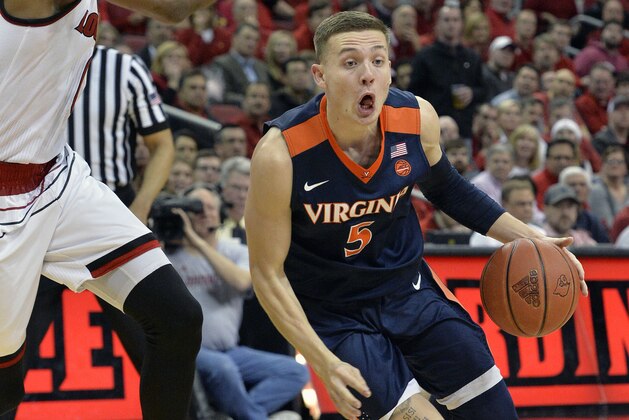 Virginia guard Kyle Guy (5)attempts to drive past the defense of Louisville forward V.J. King (0) during the first half of an NCAA college basketball game, Thursday, March 1, 2018, in Louisville, Ky. (AP Photo/Timothy D. Easley)