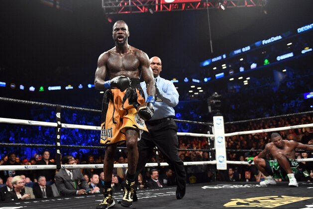 Heavyweight champion Deontay Wilder of the US is sent to his corner after knocking down contender Luis Ortiz (R) of Cuba during their WBC heavyweight title fight in New York on March 3, 2018. / AFP PHOTO / Timothy A. CLARY        (Photo credit should read TIMOTHY A. CLARY/AFP/Getty Images)
