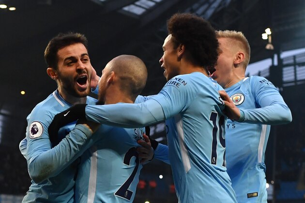 Manchester City's Portuguese midfielder Bernardo Silva (L) celebrates scoring the opening goal with teammates during the English Premier League football match between Manchester City and Chelsea at the Etihad Stadium in Manchester, north west England on March 4, 2018. / AFP PHOTO / Anthony Devlin / RESTRICTED TO EDITORIAL USE. No use with unauthorized audio, video, data, fixture lists, club/league logos or 'live' services. Online in-match use limited to 75 images, no video emulation. No use in betting, games or single club/league/player publications.  /         (Photo credit should read ANTHONY DEVLIN/AFP/Getty Images)