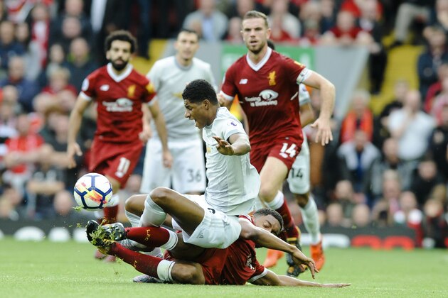 Manchester United's Marcus Rashford, top, and Liverpool's Joe Gomez, bottom, during the English Premier League soccer match between Liverpool and Manchester United at Anfield, Liverpool, England, Saturday, Oct. 14, 2017. (AP Photo/Rui Vieira)