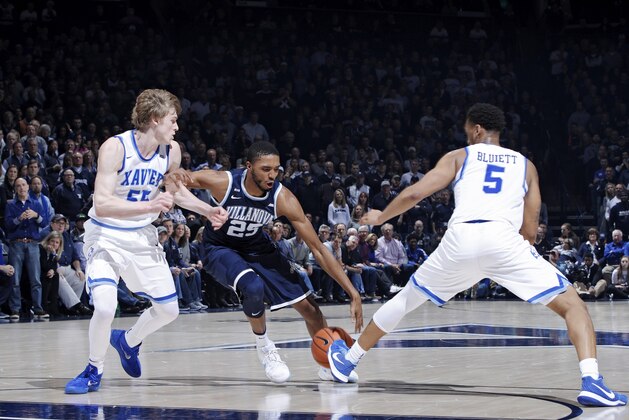 CINCINNATI, OH - FEBRUARY 17: Mikal Bridges #25 of the Villanova Wildcats handles the ball while defended by J.P. Macura #55 and Trevon Bluiett #5 of the Xavier Musketeers during a game at Cintas Center on February 17, 2018 in Cincinnati, Ohio. Villanova won 95-79. (Photo by Joe Robbins/Getty Images)