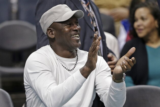 Charlotte Hornets owner Michael Jordan applauds his team as he watches in the second half of an NBA basketball game against the Orlando Magic in Charlotte, N.C., Friday, March 10, 2017. The Hornets won 121-81. (AP Photo/Chuck Burton)