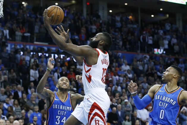 Houston Rockets guard James Harden, center, shoots between Oklahoma City Thunder guard Josh Huestis (34) and guard Russell Westbrook (0) in the first half of an NBA basketball game in Oklahoma City, Tuesday, March 6, 2018. (AP Photo/Sue Ogrocki)