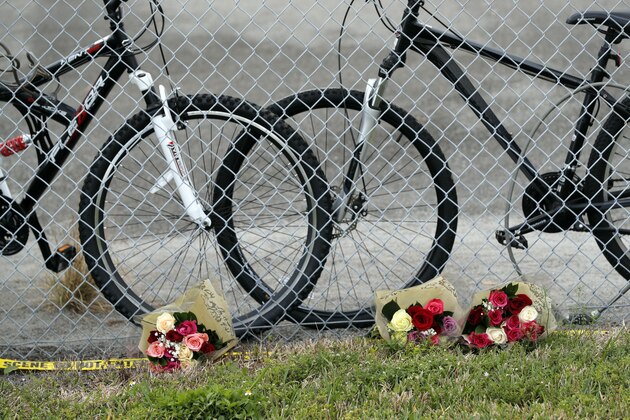 Flowers are placed near un-retrieved bicycles outside the Marjory Stoneman Douglas High School in Parkland, Fla., Sunday, Feb. 18, 2018, where 17 people were killed in a mass shooting on Wednesday.  Authorities opened the streets around the school, which had been closed since the shootings. Nikolas Cruz, a former student, was charged with 17 counts of premeditated murder. (AP Photo/Gerald Herbert)