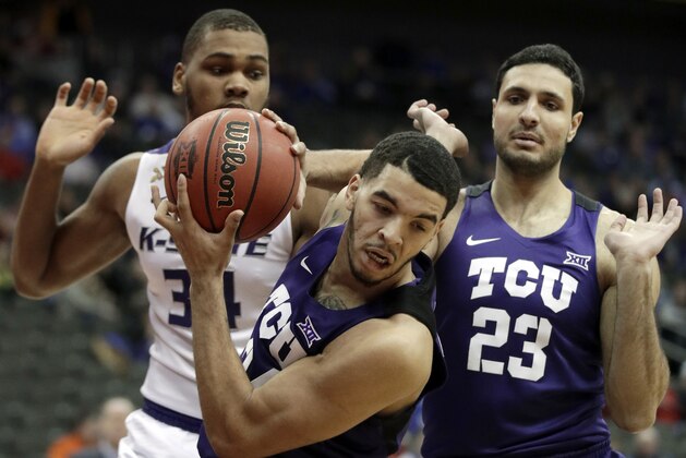 TCU guard Kenrich Williams, front, rebounds in front of Kansas State forward Levi Stockard III (34) and TCU forward Ahmed Hamdy-Mohamed (23) during the first half of an NCAA college basketball game in quarterfinals of the Big 12 conference tournament in Kansas City, Mo., Thursday, March 8, 2018. (AP Photo/Orlin Wagner)