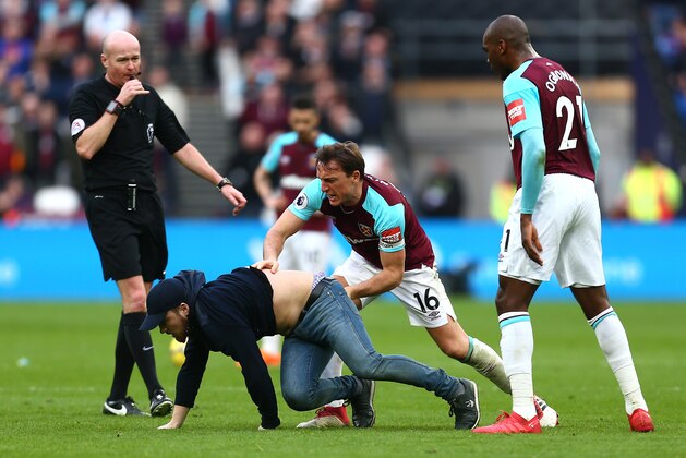 LONDON, ENGLAND - MARCH 10: Mark Noble of West Ham United clashes with a pitch invader during the Premier League match between West Ham United and Burnley at London Stadium on March 10, 2018 in London, England.  (Photo by Jordan Mansfield/Getty Images)