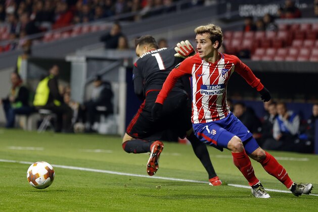Atletico Madrid's Antoine Griezmann, right, is challenged by Lokomotiv goalkeeper Guilherme during the Europa League Round of 16 first leg soccer match between Atletico Madrid and Lokomotiv Moscow at the Metropolitano stadium in Madrid, Thursday, March 8, 2018. (AP Photo/Francisco Seco)