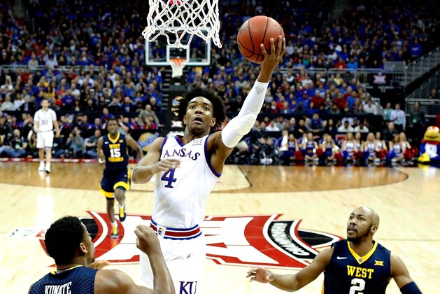KANSAS CITY, MO - MARCH 10:  Devonte' Graham #4 of the Kansas Jayhawks drives toward the basket as Sagaba Konate #50 and Jevon Carter #2 of the West Virginia Mountaineers defend during the Big 12 Basketball Tournament Championship game at Sprint Center on March 10, 2018 in Kansas City, Missouri.  (Photo by Jamie Squire/Getty Images)