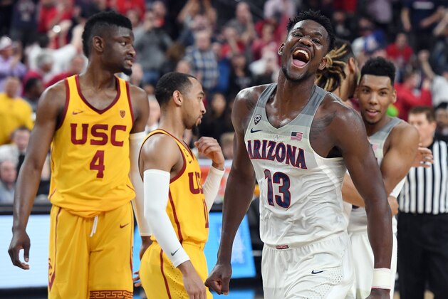 LAS VEGAS, NV - MARCH 10:  Chimezie Metu #4 and Jordan McLaughlin #11 of the USC Trojans look on as Deandre Ayton #13 of the Arizona Wildcats celebrates after the Wildcats defeated the Trojans 75-61 to win the championship game of the Pac-12 basketball tournament at T-Mobile Arena on March 10, 2018 in Las Vegas, Nevada.  (Photo by Ethan Miller/Getty Images)