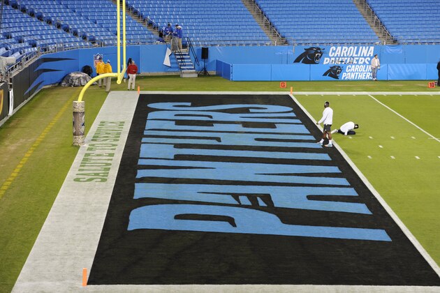 Players warm up near a Salute to Service logo on the field before an NFL football game between the Carolina Panthers and the Miami Dolphins in Charlotte, N.C., Monday, Nov. 13, 2017. (AP Photo/Mike McCarn)
