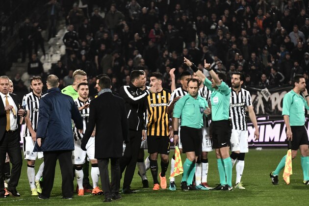 Referees (R) and players stand in confusion on the pitch, during incidents following the referee's decision to disallow PAOK an injury-time goal on March 11, 2018 during the Greek Superleague football match PAOK Thessaloniki vs AEK Athens on March 11, 2018 in Thessaloniki. / AFP PHOTO / SAKIS MITROLIDIS        (Photo credit should read SAKIS MITROLIDIS/AFP/Getty Images)