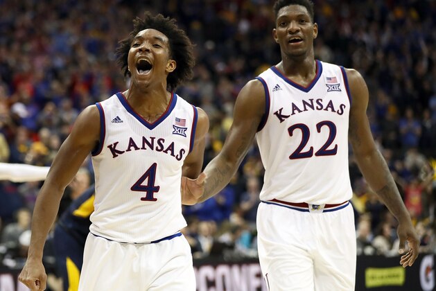 KANSAS CITY, MO - MARCH 10:  Devonte' Graham #4 of the Kansas Jayhawks celebrates with Silvio De Sousa #22 after the Jayhawks defeated the West Virginia Mountaineers 81-70 to win the Big 12 Basketball Tournament Championship game at Sprint Center on March 10, 2018 in Kansas City, Missouri.  (Photo by Jamie Squire/Getty Images)