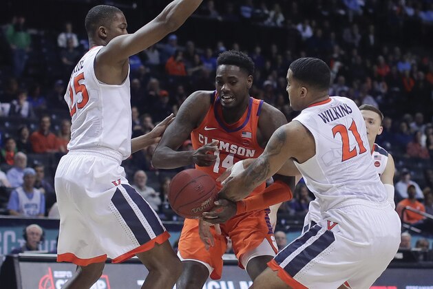 Clemson forward Elijah Thomas (14) is double-teamed by Virginia forward Mamadi Diakite (25) and forward Isaiah Wilkins (21) during the first half of an NCAA college basketball game in the Atlantic Coast Conference men's tournament semifinals Friday, March 9, 2018, in New York. (AP Photo/Julie Jacobson)