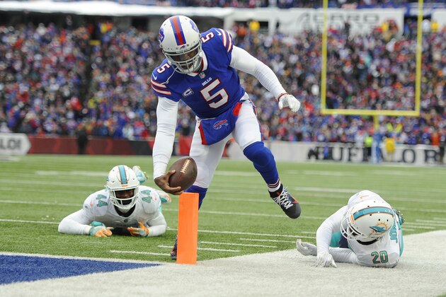 Buffalo Bills quarterback Tyrod Taylor (5) rushes past Miami Dolphins' Stephone Anthony (44) and Reshad Jones (20) for a touchdown during the first half of an NFL football game Sunday, Dec. 17, 2017, in Orchard Park, N.Y. (AP Photo/Adrian Kraus)