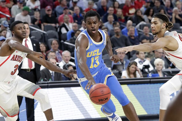 UCLA's Kris Wilkes (13) drives between Arizona's Dylan Smith (3) and Keanu Pinder (25 during the first half of an NCAA college basketball game in the semifinals of the Pac-12 men's tournament Friday, March 9, 2018, in Las Vegas. (AP Photo/Isaac Brekken)