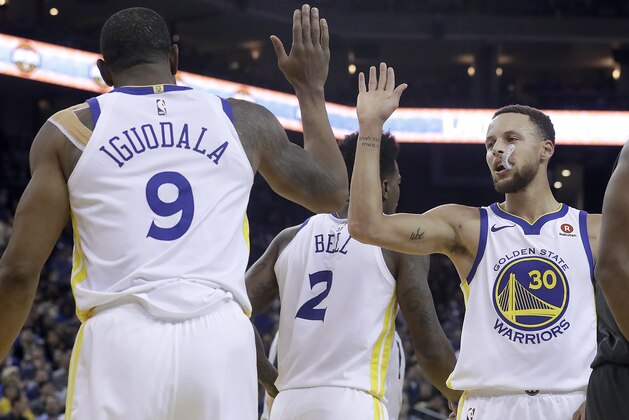 Golden State Warriors forward Andre Iguodala (9) and guard Stephen Curry (30) celebrate during the first half of the team's NBA basketball game against the Brooklyn Nets in Oakland, Calif., Tuesday, March 6, 2018. (AP Photo/Jeff Chiu)