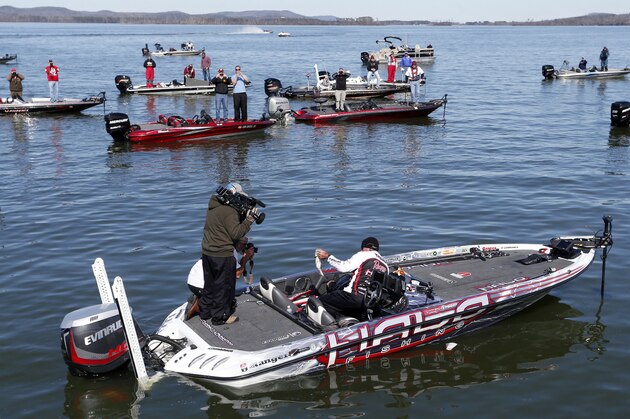 Randall Tharp, Port Saint Joe, Fla., holds up a bass for spectators following him on the second day of the Bassmaster Classic, Saturday, Feb. 22, 2014, in Guntersville, Ala. Tharp was bumped from first to second by 1 ounce by Edwin Evers, Talala, Okla. The field will be cut to the top 25 anglers for the final day of competition. (AP Photo/Hal Yeager)
