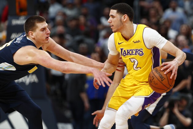 Denver Nuggets center Nikola Jokic, left, reaches for the ball controlled by Los Angeles Lakers guard Lonzo Ball during the second half of an NBA basketball game Friday, March 9, 2018, in Denver. The Nuggets won 125-116. (AP Photo/David Zalubowski)