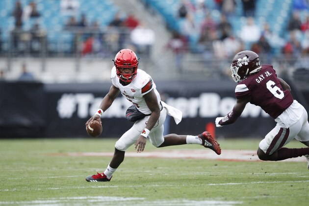 JACKSONVILLE, FL - DECEMBER 30: Lamar Jackson #8 of the Louisville Cardinals looks to pass while under pressure from Willie Gay Jr. #6 of the Mississippi State Bulldogs during the TaxSlayer Bowl at EverBank Field on December 30, 2017 in Jacksonville, Florida. The Bulldogs won 31-27. (Photo by Joe Robbins/Getty Images)