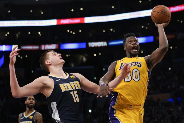 Los Angeles Lakers forward Julius Randle, right, attempts a shot while Denver Nuggets center Nikola Jokic defends during the second half of an NBA basketball game in Los Angeles, Tuesday, March 13, 2018. Los Angeles defeated Denver 112-103. (AP Photo/Kelvin Kuo)