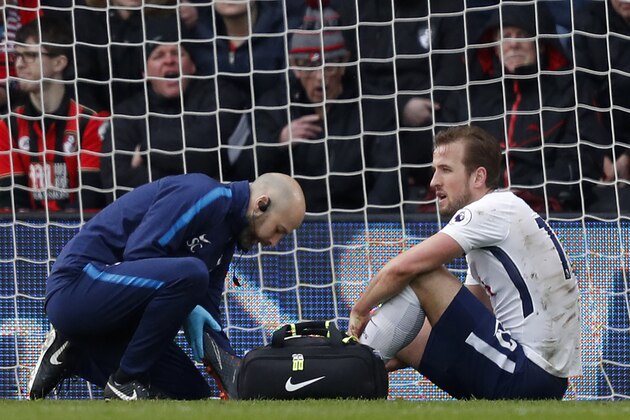 Tottenham Hotspur's English striker Harry Kane (R) receives medical attention after picking up an injury during the English Premier League football match between Bournemouth and Tottenham Hotspur at the Vitality Stadium in Bournemouth, southern England on March 11, 2018. / AFP PHOTO / Adrian DENNIS / RESTRICTED TO EDITORIAL USE. No use with unauthorized audio, video, data, fixture lists, club/league logos or 'live' services. Online in-match use limited to 75 images, no video emulation. No use in betting, games or single club/league/player publications.  /         (Photo credit should read ADRIAN DENNIS/AFP/Getty Images)