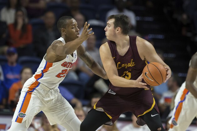 Loyola of Chicago center Cameron Krutwig (25) looks to pass around Florida forward Keith Stone (25) during the second half of an NCAA college basketball game in Gainesville, Fla., Wednesday, Dec. 6, 2017. Loyola of Chicago won 65-59. (AP Photo/Ron Irby)