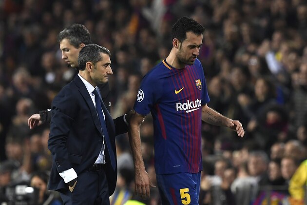 Barcelona's Spanish midfielder Sergio Busquets (R) walks with Barcelona's Spanish coach Ernesto Valverde as he is substituted during the UEFA Champions League round of sixteen second leg football match between FC Barcelona and Chelsea FC at the Camp Nou stadium in Barcelona on March 14, 2018. / AFP PHOTO / LLUIS GENE        (Photo credit should read LLUIS GENE/AFP/Getty Images)