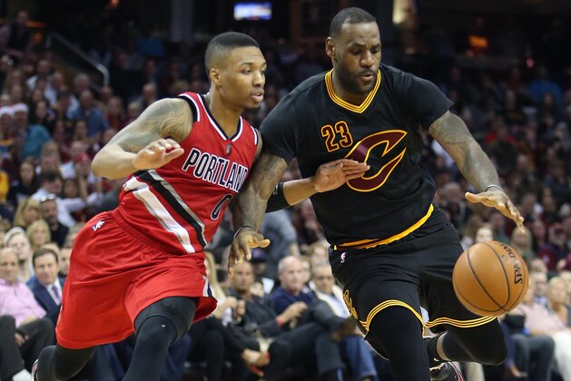 Cleveland Cavaliers forward LeBron James (23) drives on Portland Trail Blazers guard Damian Lillard (0) during the second half of an NBA basketball game Tuesday, Dec. 8, 2015, in Cleveland. The Cavaliers won 105-100. (AP Photo/Ron Schwane)