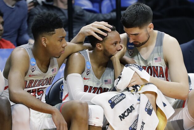 Arizona's Allonzo Trier, Parker Jackson-Cartwright and Dusan Ristic, from left, sit on the bench late in the second half of a first-round game against Buffalo in the NCAA men's college basketball tournament Thursday, March 15, 2018, in Boise, Idaho. Buffalo won 89-68. (AP Photo/Otto Kitsinger)
