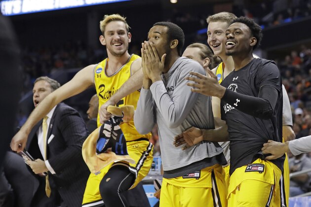 UMBC players celebrate a teammate's basket against Virginia during the second half of a first-round game in the NCAA men's college basketball tournament in Charlotte, N.C., Friday, March 16, 2018. (AP Photo/Gerry Broome)