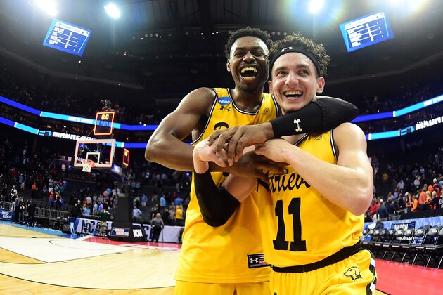 CHARLOTTE, NC - MARCH 16:  K.J. Maura #11 and teammate Jourdan Grant #5 of the UMBC Retrievers celebrate their 74-54 victory over the Virginia Cavaliers during the first round of the 2018 NCAA Men's Basketball Tournament at Spectrum Center on March 16, 2018 in Charlotte, North Carolina.  (Photo by Jared C. Tilton/Getty Images)