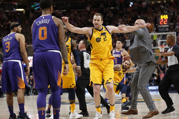 Phoenix Suns interim coach Jay Triano, right, grabs Utah Jazz forward Joe Ingles (2) as he goes after Suns forward Marquese Chriss (0) after Jazz guard Ricky Rubio (3) was shoved to the court during the second half of an NBA basketball game Thursday, March 15, 2018, in Salt Lake City. Suns' Jared Dudley and Chriss were ejected. (AP Photo/Rick Bowmer)