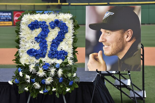 A photo of former Toronto Blue Jays pitcher Roy Halladay and a floral arrangement of his Toronto jersey number are on display during a memorial tribute for Halladay at the Philadelphia Phillies spring training baseball stadium, Tuesday, Nov. 14, 2017, in Clearwater, Fla. (AP Photo/Steve Nesius)