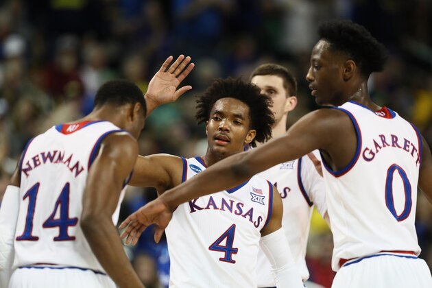 WICHITA, KS - MARCH 17:  Devonte' Graham #4 and Marcus Garrett #0 of the Kansas Jayhawks show comaraderie with teammate Malik Newman #14 as they take on the Seton Hall Pirates in the first half during the second round of the 2018 NCAA Men's Basketball Tournament at INTRUST Bank Arena on March 17, 2018 in Wichita, Kansas.  (Photo by Jamie Squire/Getty Images)