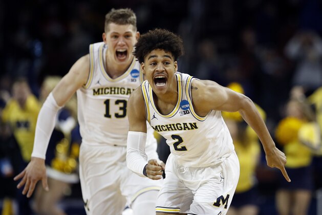 Michigan guard Jordan Poole (2) is chased by forward Moritz Wagner (13) after making a 3-point basket at the buzzer to win an NCAA men's college basketball tournament second-round game against Houston on Saturday, March 17, 2018, in Wichita, Kan. Michigan won 64-63. (AP Photo/Charlie Riedel)