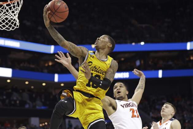 UMBC's Jairus Lyles (10) drives past Virginia's Isaiah Wilkins (21) and Kyle Guy (5) during the second half of a first-round game in the NCAA men's college basketball tournament in Charlotte, N.C., Friday, March 16, 2018. (AP Photo/Gerry Broome)