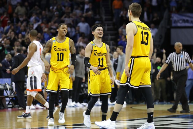 CHARLOTTE, NC - MARCH 16:  Teammates Jairus Lyles #10, K.J. Maura #11 and Joe Sherburne #13 of the UMBC Retrievers react against the Virginia Cavaliers during the first round of the 2018 NCAA Men's Basketball Tournament at Spectrum Center on March 16, 2018 in Charlotte, North Carolina.  (Photo by Streeter Lecka/Getty Images)