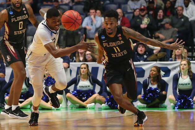 NASHVILLE, TN - MARCH 18:  Braian Angola #11 of the Florida State Seminoles fights for a loose ball with Naji Marshall #13 of the Xavier Musketeers during the first half in the second round of the 2018 Men's NCAA Basketball Tournament at Bridgestone Arena on March 18, 2018 in Nashville, Tennessee.  (Photo by Frederick Breedon/Getty Images)