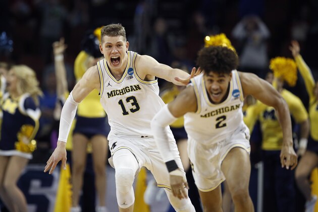 Michigan guard Jordan Poole (2) is chased by forward Moritz Wagner (13) after making a 3-point basket at the buzzer to win an NCAA men's college basketball tournament second-round game against Houston on Saturday, March 17, 2018, in Wichita, Kan. Michigan won 64-63. (AP Photo/Charlie Riedel)