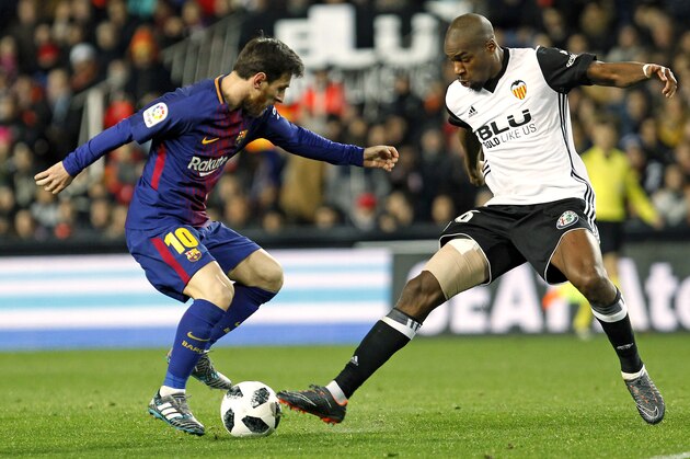 FC Barcelona's Lionel Messi, left, duels for the ball with Valencia's Geoffrey Kondogbia, right, during the Spanish Copa del Rey, semifinal, second leg, soccer match between FC Barcelona and Valencia at the Mestalla stadium in Valencia, Spain, Thursday Feb. 8, 2018. (AP Photo/Alberto Saiz)